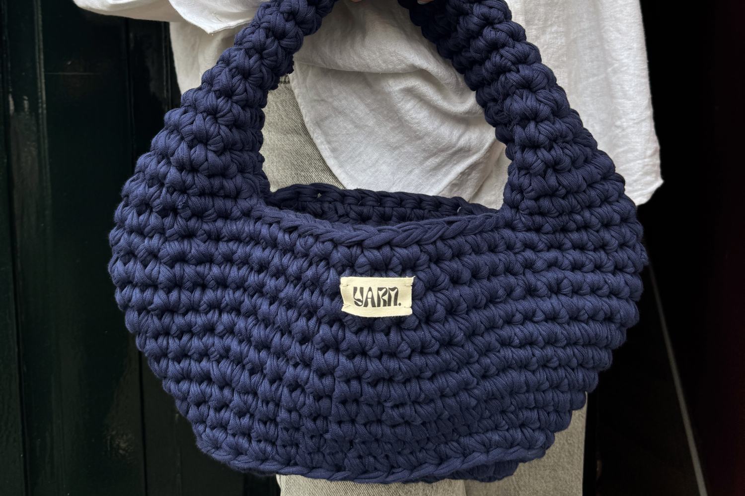 Navy crochet shoulder bag with the Yarn. label